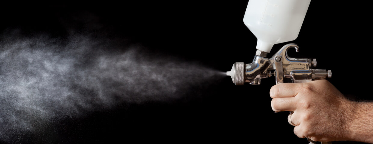 close up of spray gun on black background, spray coating concept