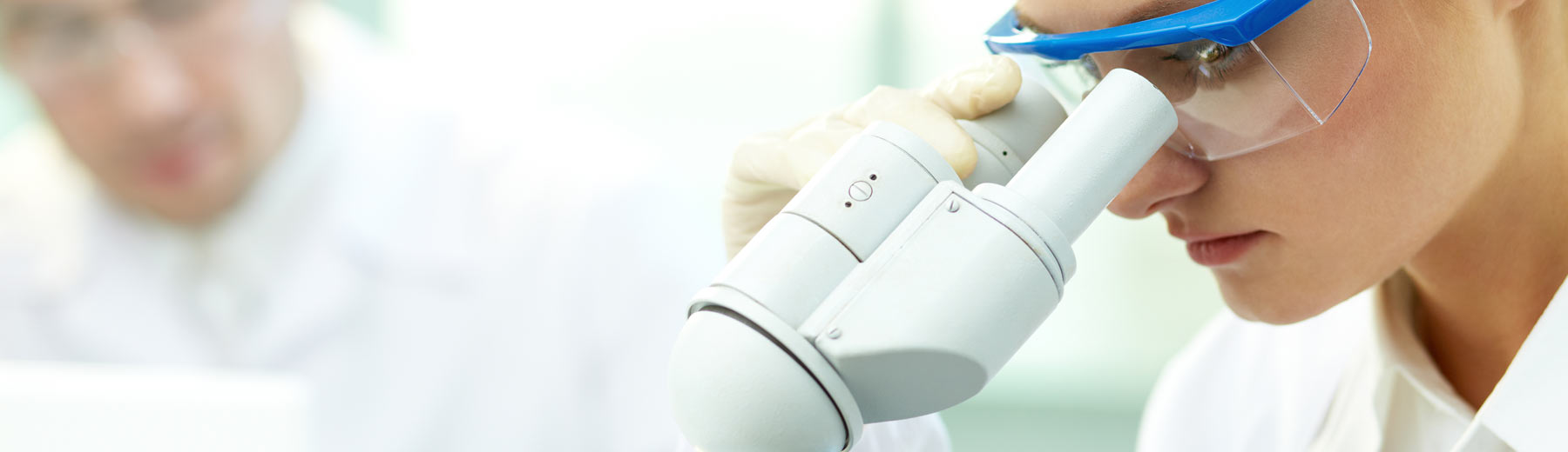 Woman looking through a microscope in a laboratory