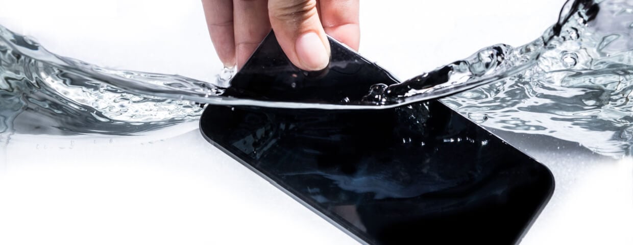 hand holding smart phone in water